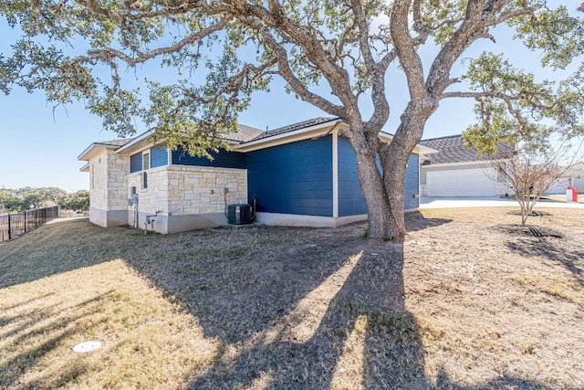 404 Eagle Dr, San Marcos, TX 78666 - view of side of home featuring stone siding, driveway, and a garage