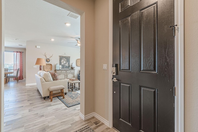 foyer featuring ceiling fan and light wood-type flooring