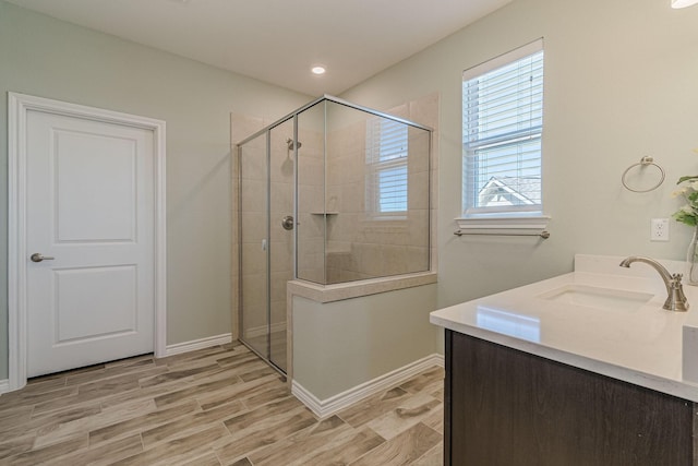 bathroom with hardwood / wood-style flooring, vanity, and tiled shower