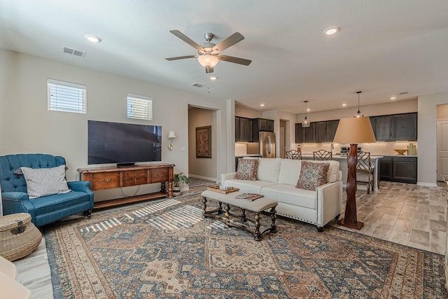 living room featuring wood-type flooring and ceiling fan