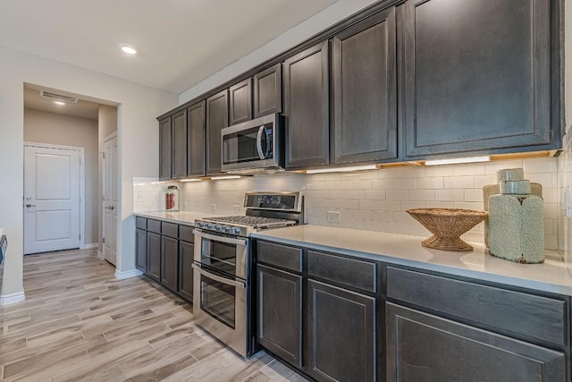 404 Eagle Dr, San Marcos, TX 78666 - kitchen featuring appliances with stainless steel finishes, light countertops, light wood finished floors, backsplash, and recessed lighting