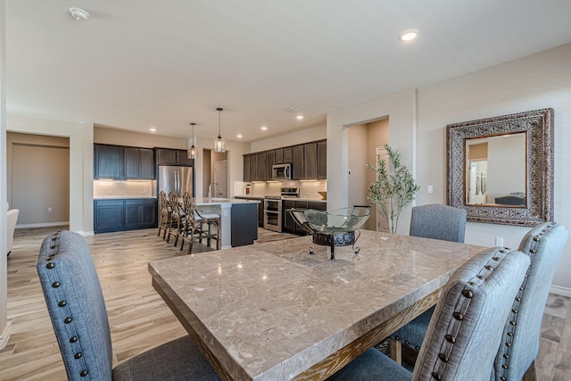 dining room featuring sink and light hardwood / wood-style floors