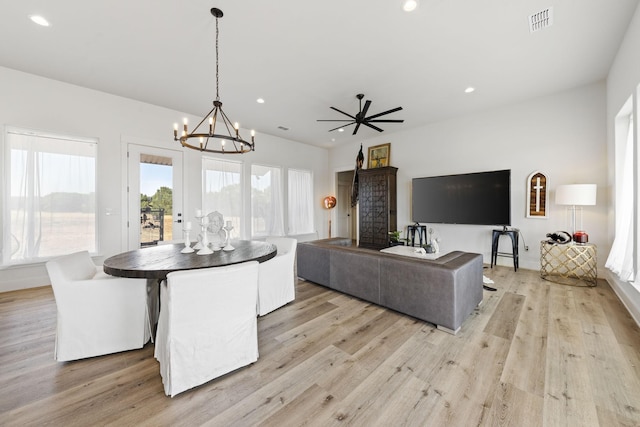 dining room featuring an inviting chandelier, a wealth of natural light, and light hardwood / wood-style floors