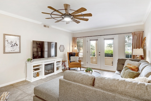 tiled living room featuring crown molding, ceiling fan, a fireplace, and french doors