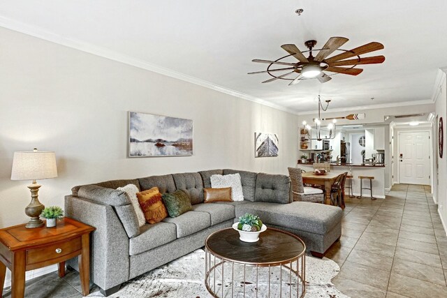 living room with ornamental molding, ceiling fan with notable chandelier, and light tile patterned floors