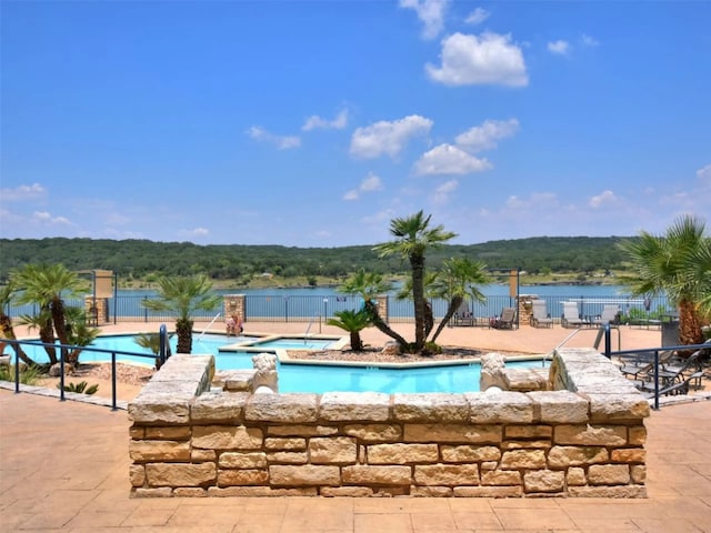 view of swimming pool featuring a water view and a patio area