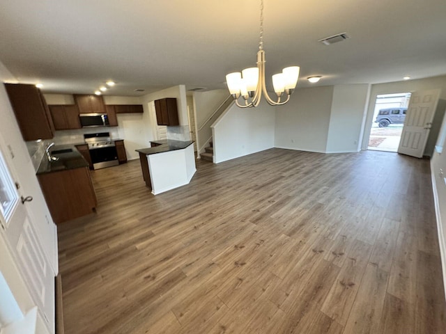 kitchen with pendant lighting, dark hardwood / wood-style floors, a chandelier, and appliances with stainless steel finishes