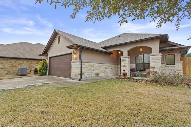 view of front of home with a garage, a front yard, and central air condition unit