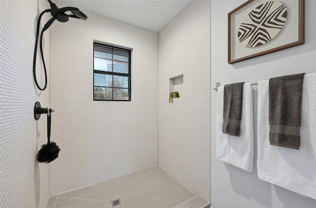 bathroom with tile patterned flooring and a tile shower