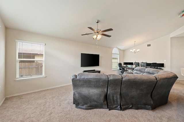 carpeted living room featuring vaulted ceiling and ceiling fan with notable chandelier