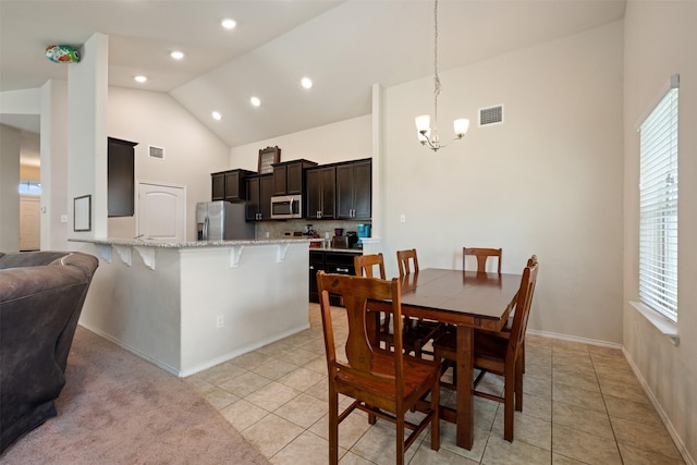 dining area with light tile patterned flooring, high vaulted ceiling, and a notable chandelier