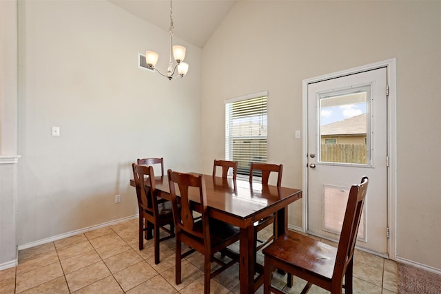 dining space featuring high vaulted ceiling, light tile patterned floors, and an inviting chandelier