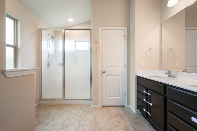 bathroom with lofted ceiling, vanity, a shower with shower door, and tile patterned flooring