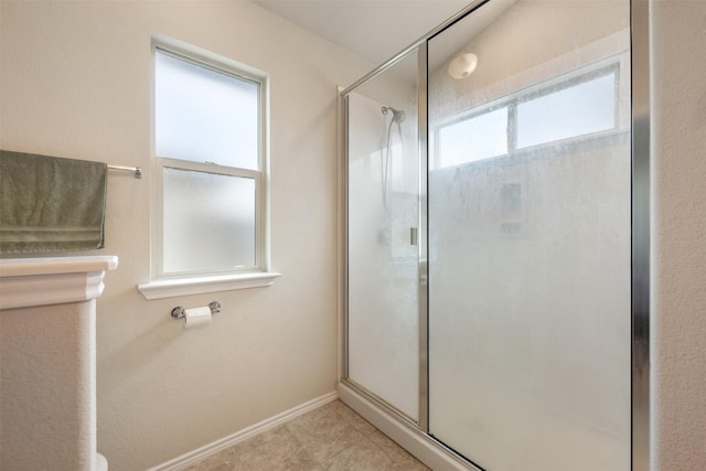 bathroom with a wealth of natural light and a shower with shower door