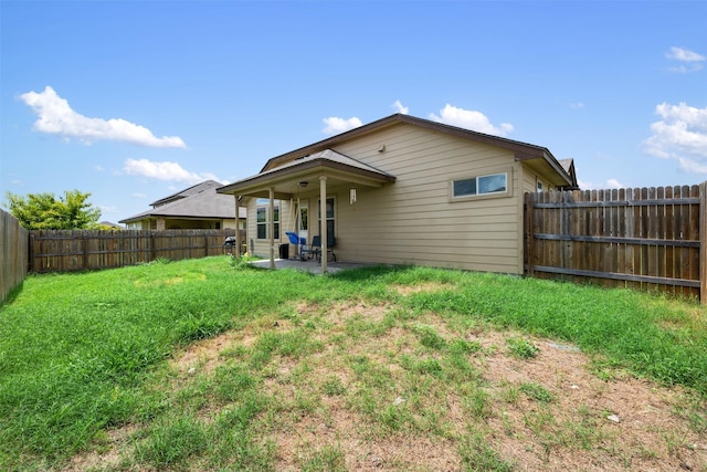 rear view of property with a patio area and a lawn