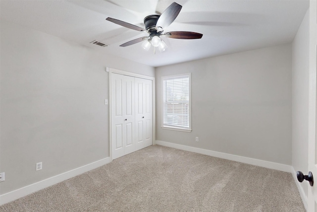 unfurnished bedroom featuring carpet flooring, ceiling fan, and a closet