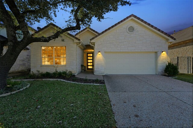 single story home featuring a yard and a garage