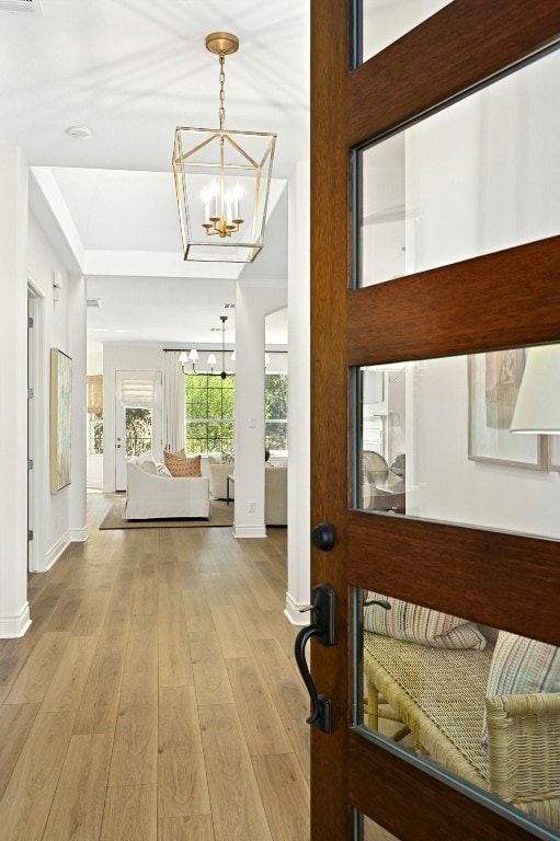 foyer entrance with a notable chandelier and light wood-type flooring