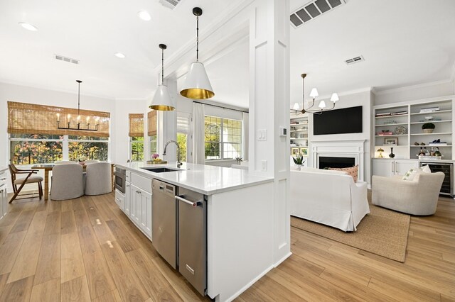 kitchen with hanging light fixtures, sink, white cabinets, and a chandelier