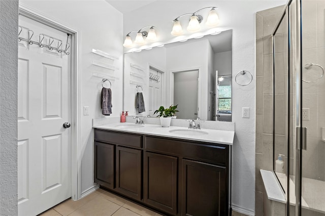 bathroom featuring tile patterned flooring, an enclosed shower, and vanity