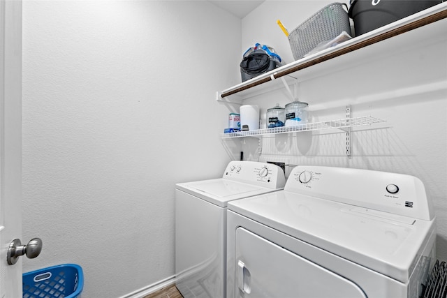 laundry room with wood-type flooring and washing machine and clothes dryer