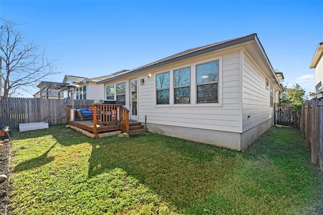 rear view of property with a yard and a deck