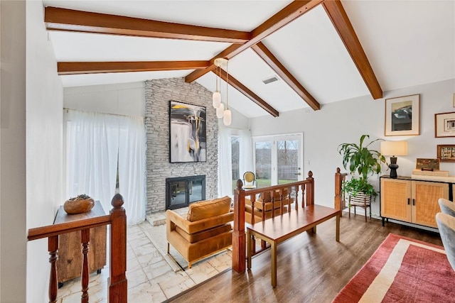 living room featuring a fireplace, lofted ceiling with beams, and hardwood / wood-style floors