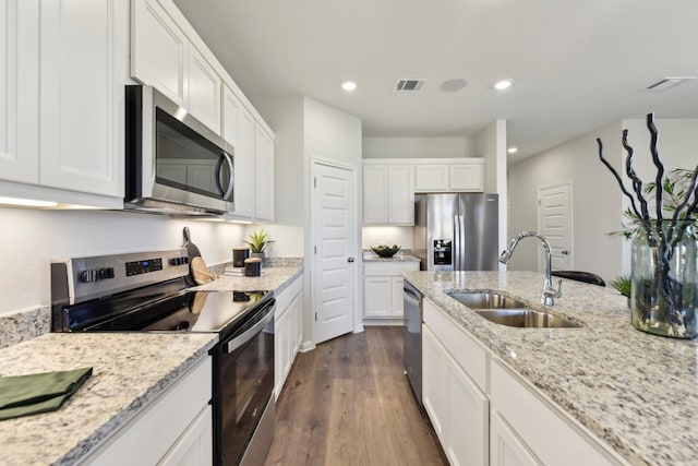 kitchen featuring sink, appliances with stainless steel finishes, dark hardwood / wood-style flooring, light stone countertops, and white cabinets