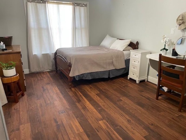 bedroom with dark hardwood / wood-style floors