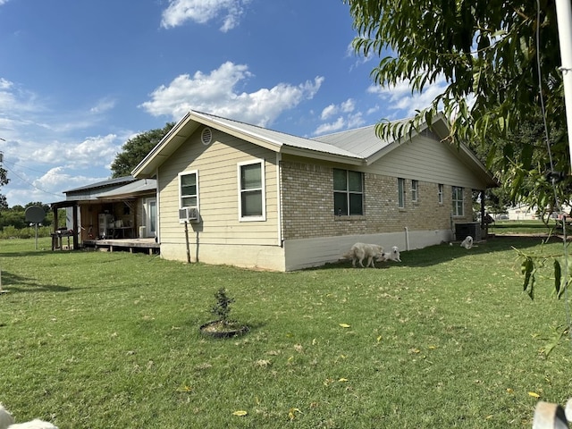 view of side of property with a yard and cooling unit