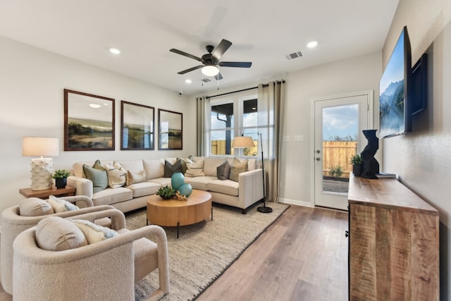 living room featuring ceiling fan and dark hardwood / wood-style floors