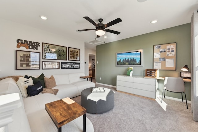 living room featuring light carpet, built in desk, and ceiling fan