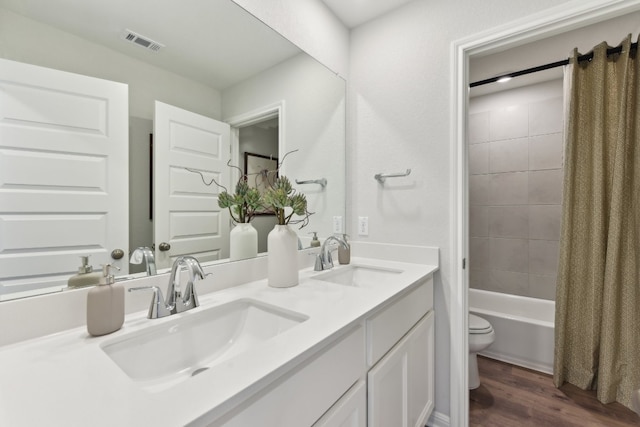 full bathroom with vanity, hardwood / wood-style floors, toilet, and shower / bath combo