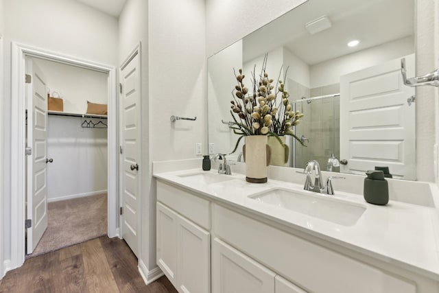 bathroom with vanity, a shower with shower door, and wood-type flooring