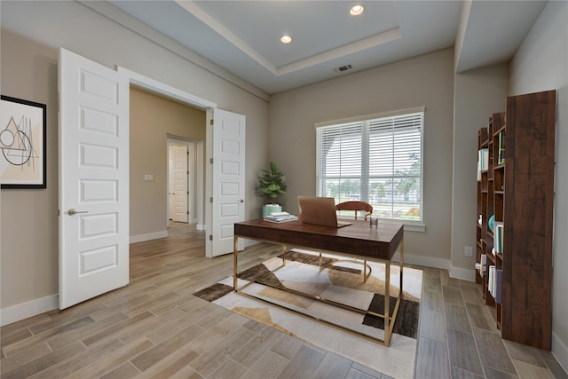 home office featuring a raised ceiling