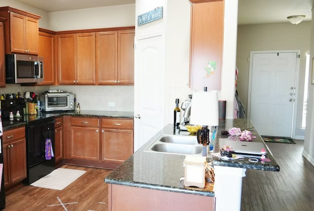 kitchen featuring sink, dark stone countertops, black range with electric stovetop, backsplash, and wood-type flooring