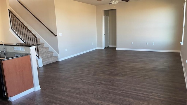 unfurnished living room with ceiling fan and dark hardwood / wood-style flooring