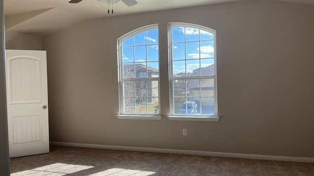 carpeted spare room with a mountain view, lofted ceiling, and ceiling fan