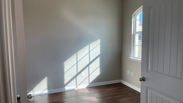 unfurnished room featuring dark hardwood / wood-style flooring and plenty of natural light