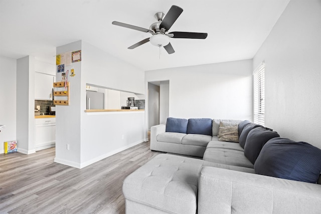 living room featuring ceiling fan and light wood-type flooring