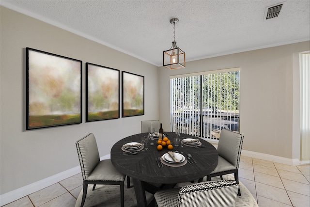 dining space with light tile patterned flooring, ornamental molding, and a textured ceiling