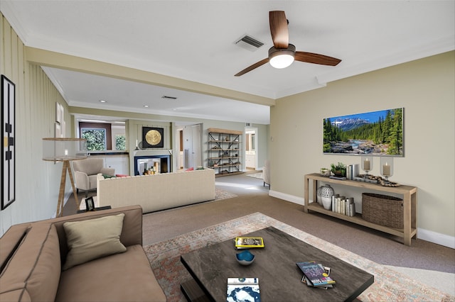 living room featuring ornamental molding, wooden walls, light carpet, and ceiling fan