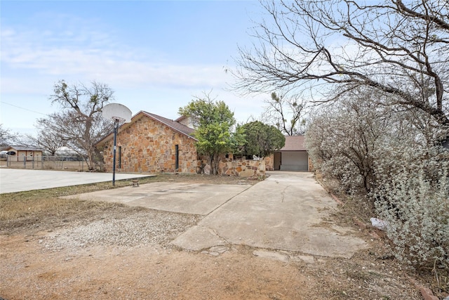 view of front of house with a garage and basketball hoop