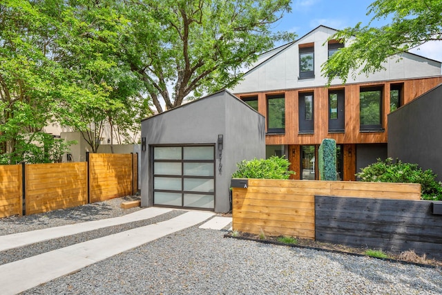 contemporary house with a garage and an outdoor structure