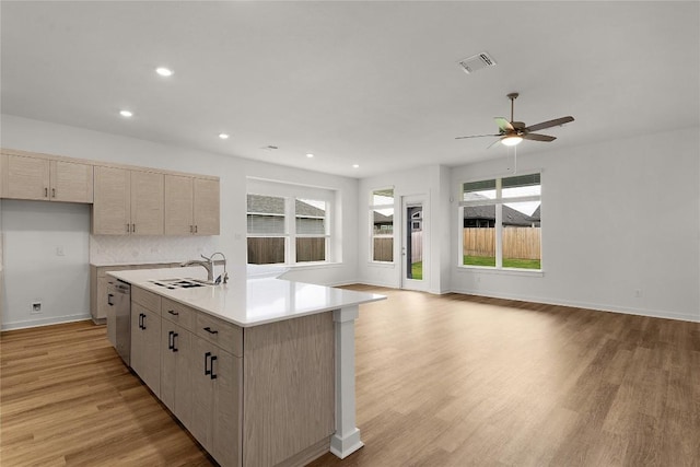 kitchen with open floor plan, stainless steel dishwasher, a ceiling fan, and light wood-style flooring