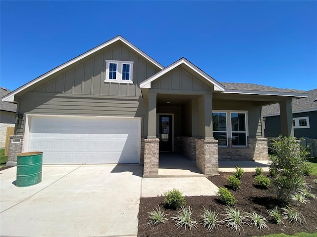 view of front of property featuring roof with shingles, board and batten siding, driveway, brick siding, and a garage