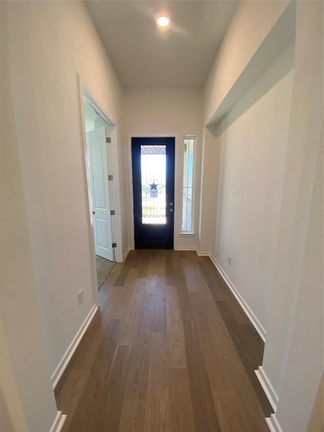 doorway to outside with baseboards and dark wood finished floors