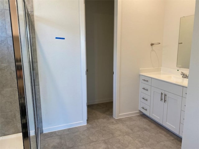 full bathroom with baseboards, vanity, and a stall shower