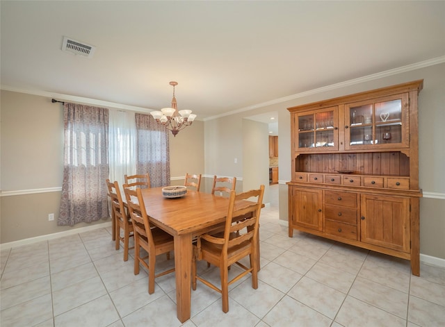 dining space with light tile patterned floors, crown molding, and a chandelier