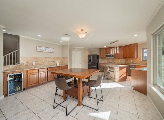 tiled dining room featuring crown molding and beverage cooler